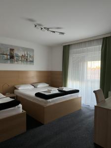 Habitación de hotel con 2 camas y ventana en Pansion Komfor Fitea, en Osijek