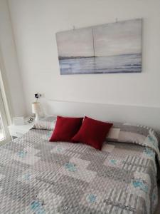 a bedroom with a bed with two red pillows at Casa Flo in Viddalba