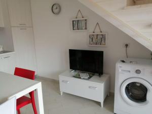 a living room with a tv and a washing machine at Casa Flo in Viddalba