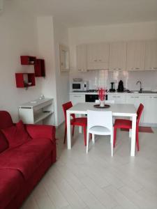 a living room with a red couch and a white table at Casa Flo in Viddalba