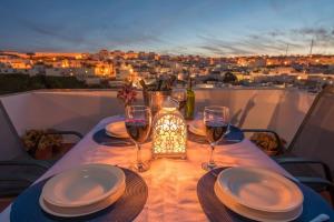 una mesa con platos y copas de vino en el balcón en La Sultana de Vejer, en Vejer de la Frontera