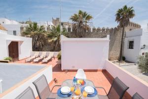 a patio with a table and chairs on a balcony at La Sultana de Vejer in Vejer de la Frontera