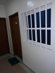 Habitación vacía con ventana y puerta en Appartement Aéroport 2, en Lomé