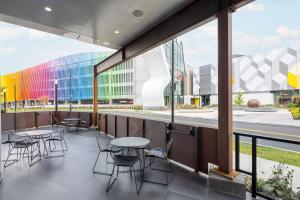 un patio con mesas y sillas y un edificio en Hampton Inn & Suites Rochester Downtown, en Rochester