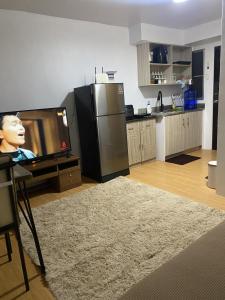 sala de estar con TV y cocina en Urban Deca Homes Tisa, en Cebú