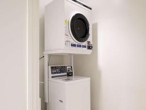 a microwave oven hanging from a wall next to a refrigerator at Comfort Inn Nagoya Sakae in Nagoya