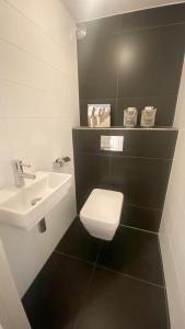 een badkamer met een wit toilet en een wastafel bij ZeePanorama in Bergen aan Zee