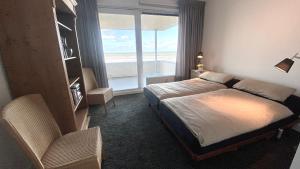 een hotelkamer met een bed en een groot raam bij ZeePanorama in Bergen aan Zee