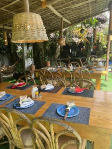 une table en bois avec des chaises et une table avec des assiettes de nourriture dans l'établissement Big Apple Dive Resort, à Puerto Galera