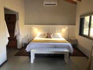 a bedroom with a bed with a bench in it at Modern Bush Living in Marloth Park +21 photos
