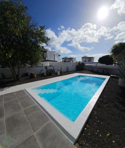een zwembad in de tuin van een huis bij VILLA ANNA With heated pool in Puerto del Carmen