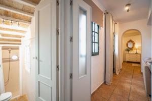 a bathroom with a white door and a hallway at La Sultana de Vejer in Vejer de la Frontera