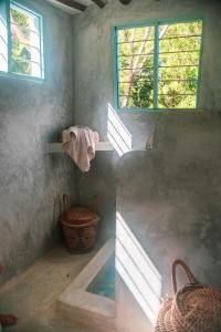baño con lavabo y ventana en Yasmin house, en Kizimkazi
