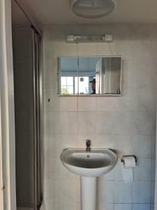 a bathroom with a sink and a mirror at Studio on Golders Green Road in London