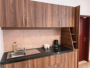 a kitchen with a sink and a counter top at Sky Suites-Byblos Hotel Osu in Accra