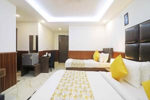 a hotel room with two beds and a tv at Hotel Amara Inn - Near Delhi Airport in New Delhi