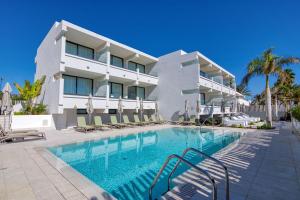 a hotel with a swimming pool in front of a building at RELAXIA BEVERLY SUITES in Playa del Ingles