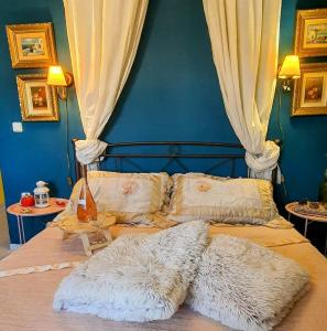 a bedroom with a bed with a blue wall at VELANIDIA HOUSE in Rafina