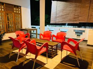 Happy Resort Yala في تيساماهاراما: مجموعة من الكراسي الحمراء وطاولة في الغرفة