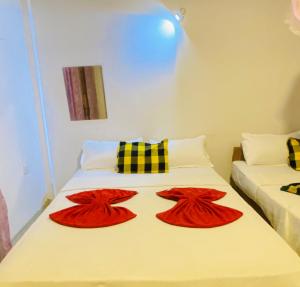 2 Betten in einem Zimmer mit roter Bettwäsche und Kissen in der Unterkunft Happy Resort Yala in Tissamaharama