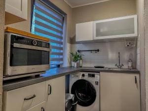 a kitchen with a microwave and a dishwasher at Joyfulhomes City Apartment in Bremen