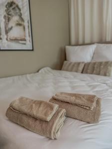 due asciugamani seduti sopra un letto bianco di Joyfulhomes City Apartment a Brema