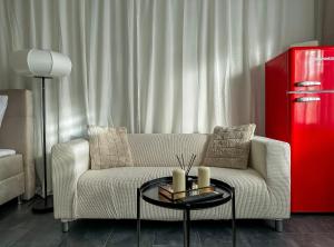 un soggiorno con divano e frigorifero rosso di Joyfulhomes City Apartment a Brema