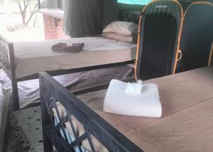 a room with a bed and a table with a white bag on it at Riverbend Camp - Self-catering Luxury Glamping Tent in Christiana