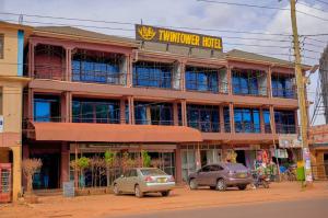 un edificio con coches estacionados frente a él en Twin towers hotel en Kampala