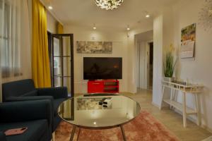 a living room with a glass table and a tv at Apartments Panorama in Veliko Tŭrnovo