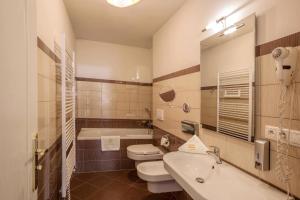 ein Badezimmer mit einem WC, einem Waschbecken und einer Badewanne in der Unterkunft Hotel Europa in Brünn