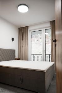 ein Schlafzimmer mit einem großen Bett und einem Fenster in der Unterkunft Apartamenty Nad Potokiem koło Karpacza in Staniszów