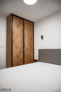 Schlafzimmer mit einem Bett und einer Holztür in der Unterkunft Apartamenty Nad Potokiem koło Karpacza in Staniszów