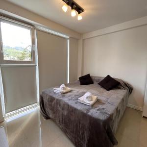 ウシュアイアにあるHappy Guest Apart 305のベッドとタオル2枚のある寝室 +6枚の写真