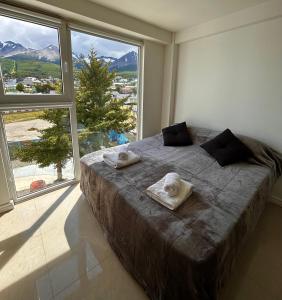 ウシュアイアにあるHappy Guest Apart 305の大きなベッドとタオル2枚のある寝室