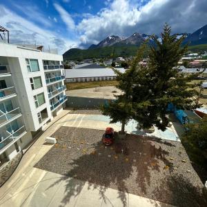 ウシュアイアにあるHappy Guest Apart 305の建物の隣の建物の屋根にある木