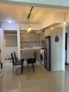 a kitchen with a table and chairs and a refrigerator at Condo in Klang. Nordica Gravit8 in Klang