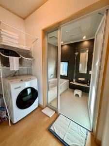 a bathroom with a washing machine and a bath tub at Snow Fever - Clique in Hakuba +6 photos