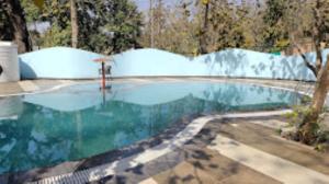 una grande piscina con recinzione intorno di MPT Jungle Camp, Panna a Rājgarh