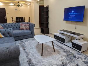 a living room with a couch and a tv at bliss Haven spaces kileleshwa 2bedroom in Nairobi