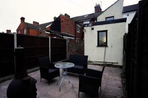 a small patio with chairs and a table and a building at 2BR Home W/ en-suite toilet, Town Centre Ipswich. in Ipswich
