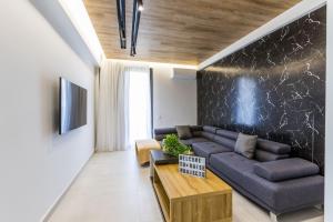 Varkiza Luxury Suites في فاري: غرفة معيشة مع أريكة وطاولة