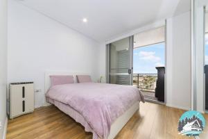 a white bedroom with a bed and a balcony at Aircabin - Burwood - Sydney - 2 Beds Apt Free Park in Sydney