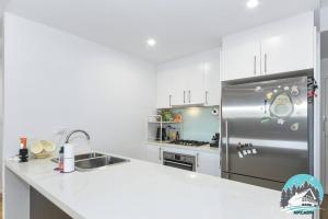 a kitchen with a stainless steel refrigerator at Aircabin - Burwood - Sydney - 2 Beds Apt Free Park in Sydney