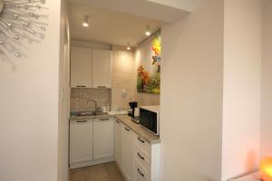 a white kitchen with a sink and a microwave at Apartments Panorama in Veliko Tŭrnovo +2 photos