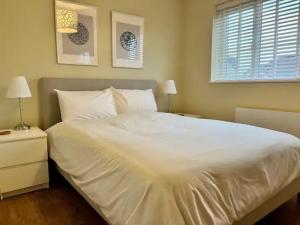 1 cama blanca grande en un dormitorio con 2 lámparas en Pass the Keys Modern Family Friendly Flat with Parking, en Rickmansworth