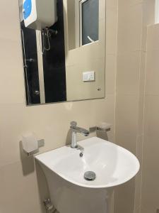 een witte wastafel in een badkamer met een spiegel bij Rush Resident Mount Lavinia in Mount Lavinia