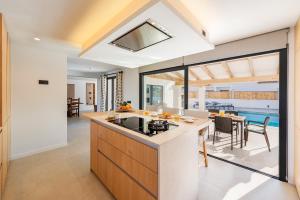 an open kitchen and dining room with a view of a pool at Villa Ana to rent in Puerto Pollensa by JS Villas in El Port