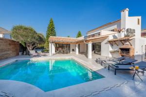 a swimming pool in the backyard of a house at Villa Ana to rent in Puerto Pollensa by JS Villas in El Port
