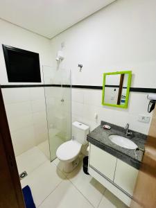 a bathroom with a toilet and a sink at Flat Gru in Guarulhos